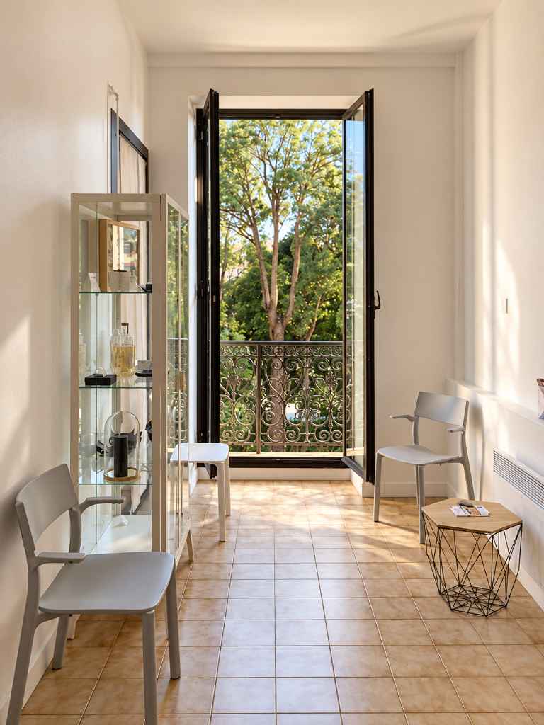 Salle d’attente du cabinet d’hypnose de Léa Khan à Nice, ouverte sur les arbres de l’avenue